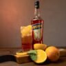a bottle of alcohol sitting on top of a wooden cutting board