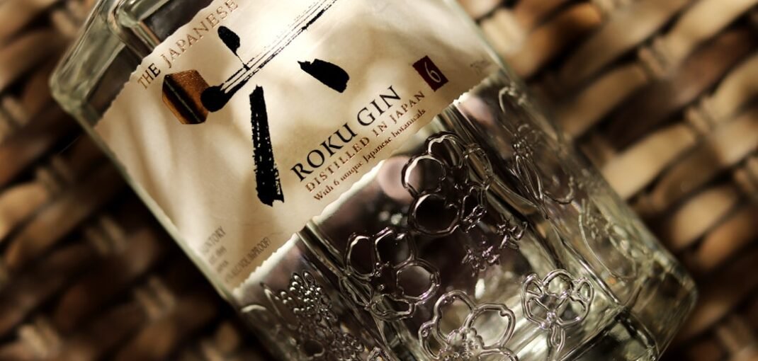 Bottle of Roku Gin with Japanese botanical ingredients including yuzu, sakura flower, and hinoki wood reflected in winter glassware