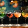 A selection of premium alcohol gift ideas arranged on a wooden surface, including whisky, gin, and wine bottles