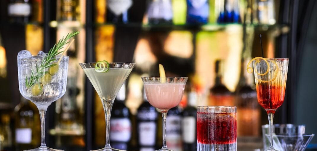 A selection of premium spirits, wine and champagne bottles arranged on a dark wooden surface for a complete buying guide