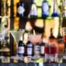 A selection of premium spirits, wine and champagne bottles arranged on a dark wooden surface for a complete buying guide