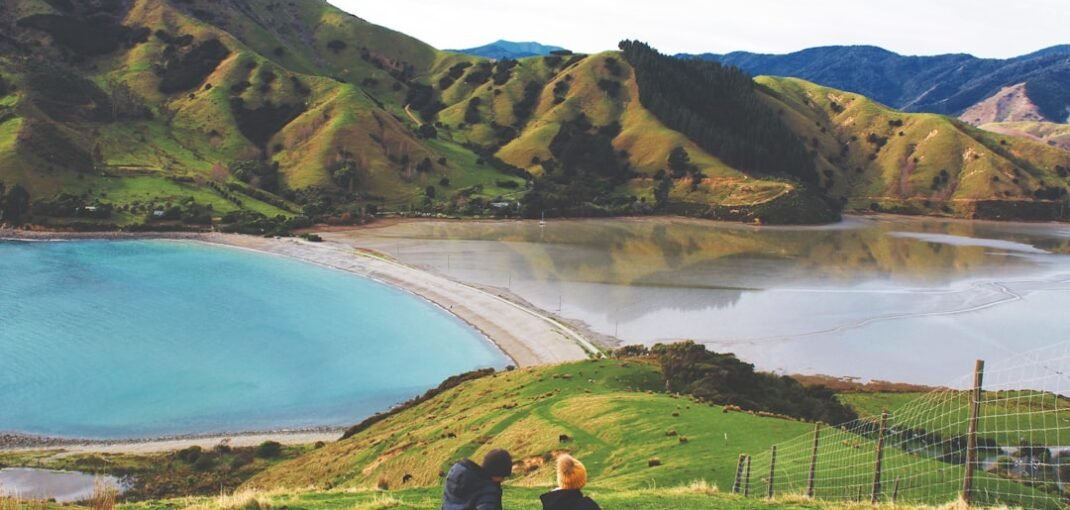 A glass of amber whisky on a wooden table with a winter New Zealand backdrop, perfect for a beginner's guide to whisky