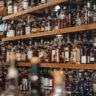 A glass of amber single malt whisky beside a bottle of blended Scotch, comparing single malt vs blended whisky styles